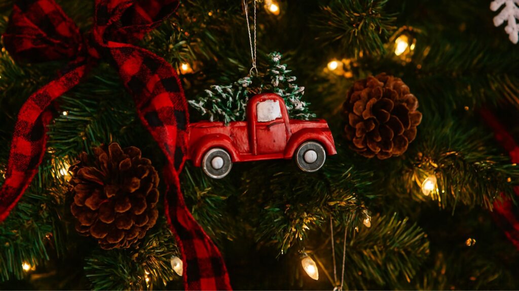 Rustic Christmas tree decorated with Dollar Tree red truck ornaments, glowing lights, and cozy festive mood