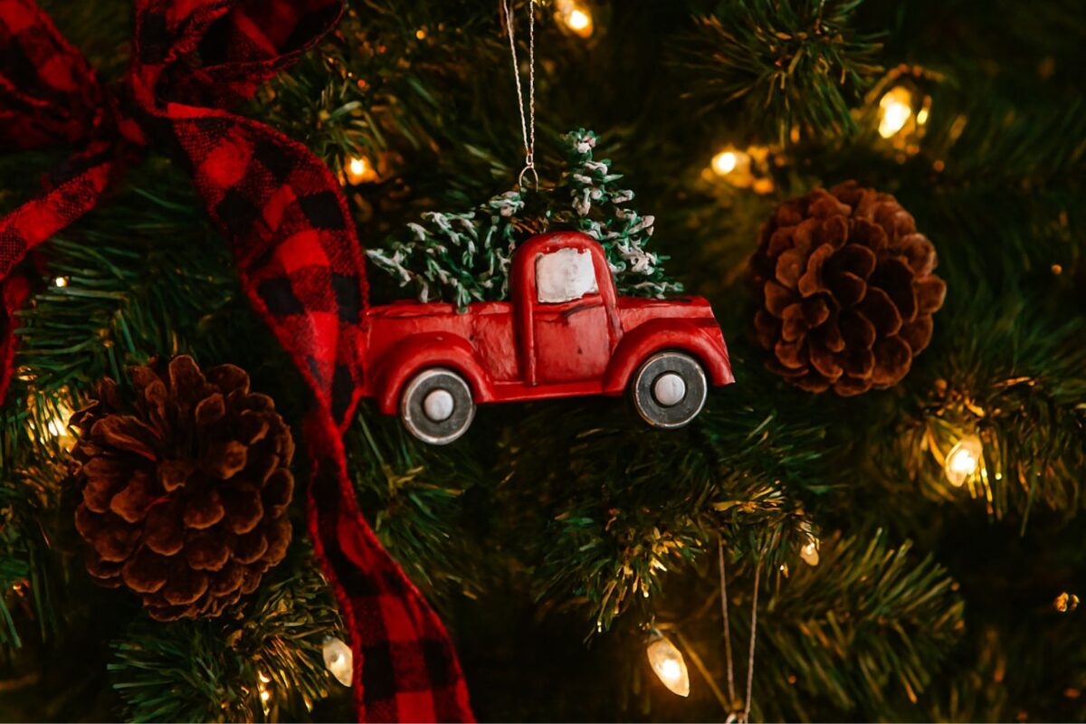 Rustic Christmas tree decorated with Dollar Tree red truck ornaments, glowing lights, and cozy festive mood